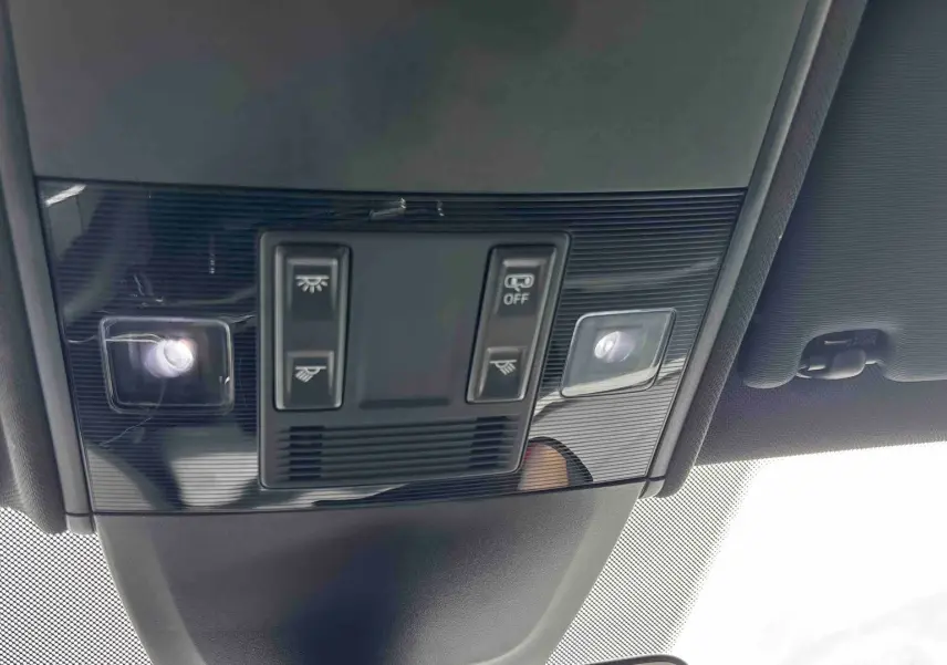 Vue en contre-plongée du plafonnier noir du Volkswagen Taigo 2025 avec commandes d’éclairage intégrées.