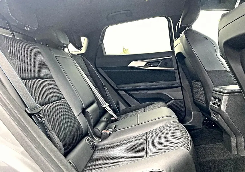 Vue intérieure côté droit de la banquette arrière noire en tissu et alcantara du Renault Austral gris schiste, avec accoudoirs et aérateurs.