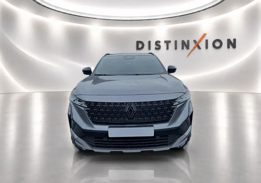 Vue frontale d'un Renault Austral gris schiste avec calandre noire et logo central dans un showroom lumineux.