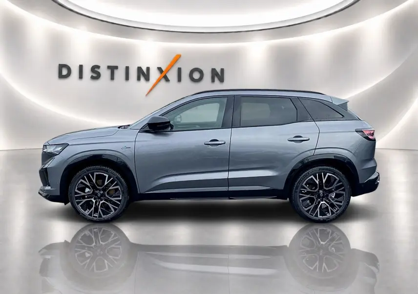 Profil droit du Renault Austral gris schiste 2026 avec jantes alu noires et toit noir dans un showroom lumineux.