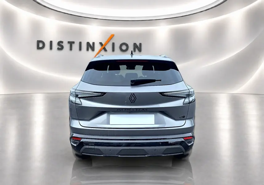 Vue arrière du Renault Austral gris schiste avec feux LED et logo distinctif sur fond lumineux "Distinxion".