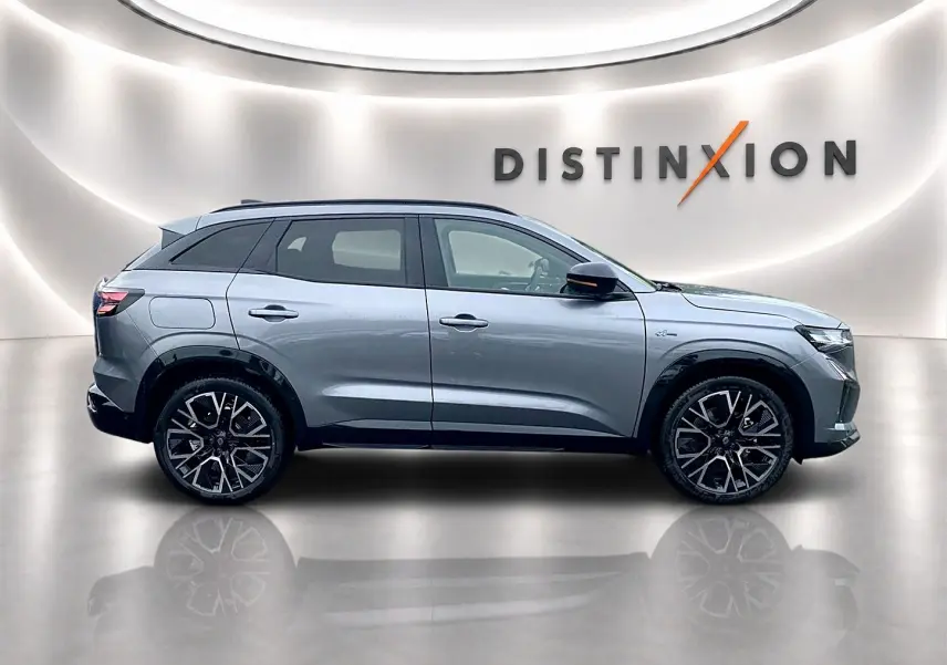 Profil droit du Renault Austral gris schiste avec jantes alu noires et toit noir dans un studio lumineux.