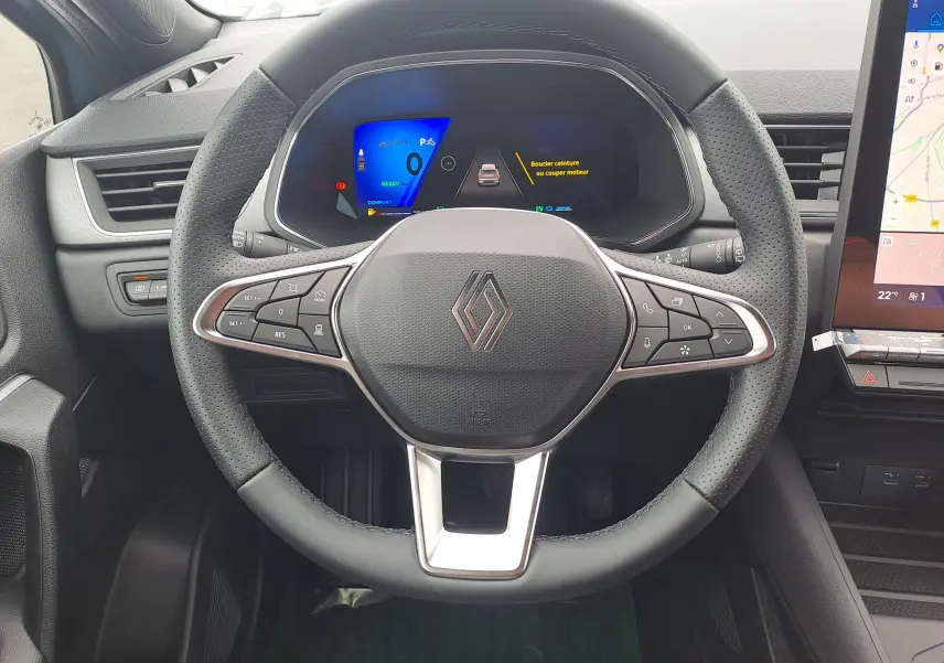 Volant en cuir perforé avec logo Renault, tableau de bord numérique et écran tactile central du Renault Symbioz 2025.