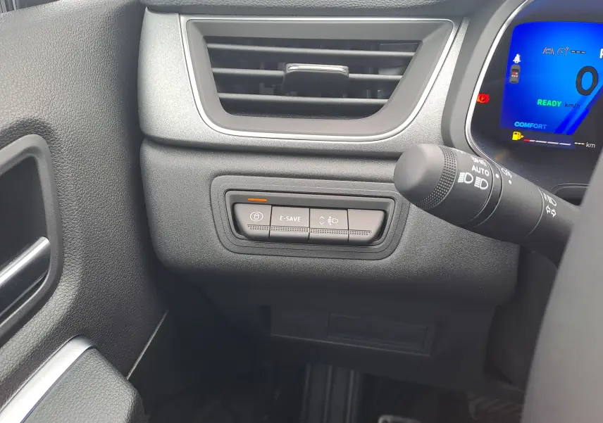 Détail intérieur côté gauche du tableau de bord Renault Symbioz bleu Mercure avec commandes E-SAVE et éclairage.
