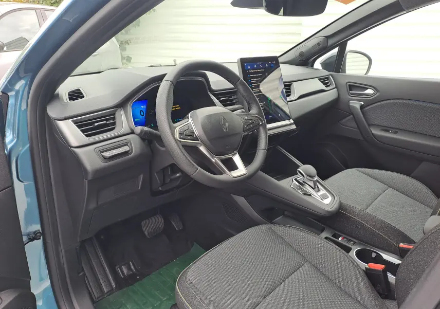 Intérieur avant droit de la Renault Symbioz bleu mercure, volant multifonction, écran tactile vertical et sellerie Techno grise.