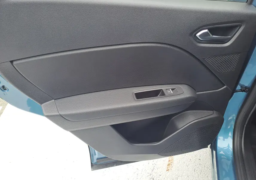 Porte côté gauche ouverte d'une Renault Symbioz bleu mercure, avec panneau intérieur noir et commande de vitre électrique.