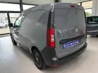 Renault Express Van gris 3/4 arrière droit en intérieur, avec porte latérale coulissante et enjoliveurs noirs.