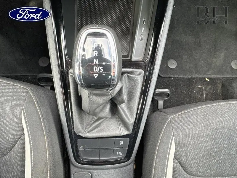 Le levier de vitesses automatique noir et chrome du Skoda Kamiq gris graphite, vu de dessus entre les sièges avant.