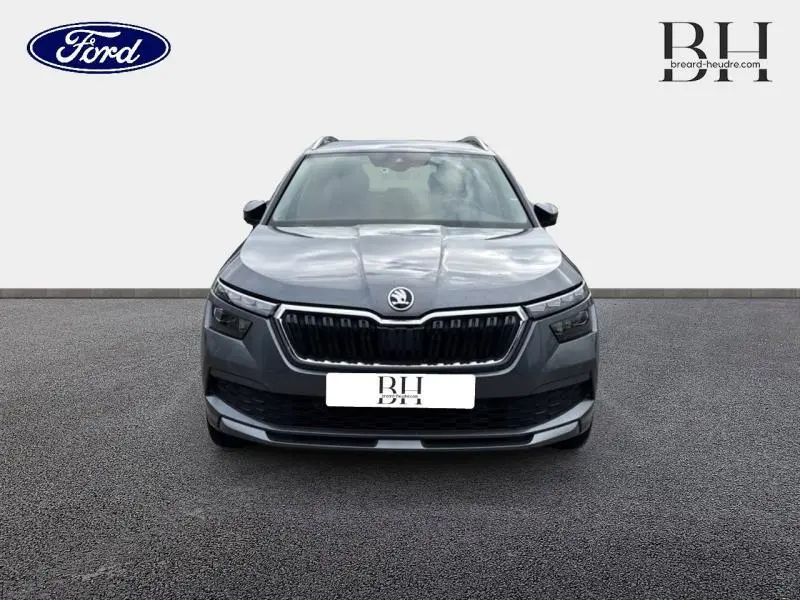 Vue frontale d'un Skoda Kamiq 1.0 TSI Evo Style gris graphite métallisé avec calandre chromée et phares LED.