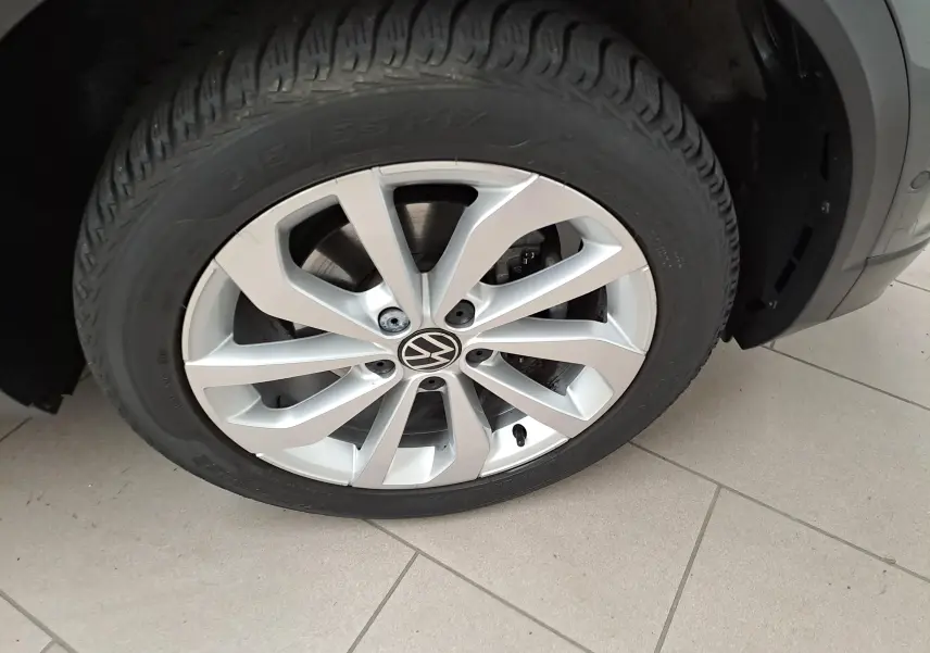 Gros plan sur la jante alliage 17'' Johannesburg d'un Volkswagen T-Roc gris Indium, mettant en valeur le logo VW central.
