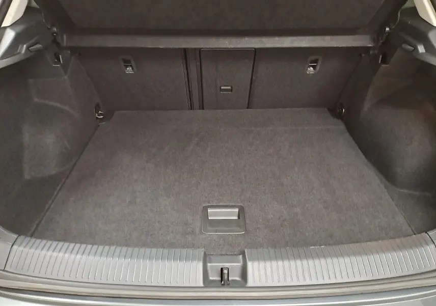 Coffre ouvert du Volkswagen T-Roc 1.5 TSI gris Indium, montrant un espace de chargement propre et spacieux.