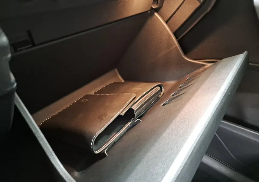 Intérieur du Volkswagen T-Roc 1.5 TSI 2024, vue sur la boîte à gants ouverte avec un porte-documents en cuir noir.