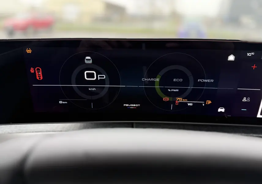 Tableau de bord numérique du Peugeot 3008 Hybrid 2025 affichant vitesse, charge et autonomie, vu de face depuis le volant.