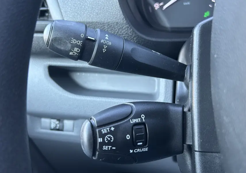Gros plan sur les commandes de régulateur et feux au volant d’un Citroën Jumpy blanc, version Fourgon M 2017.