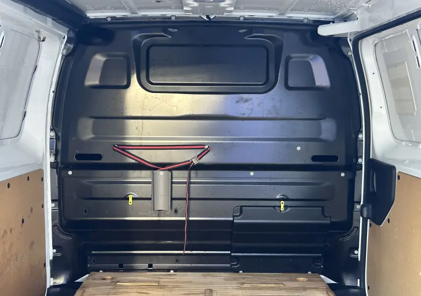 Vue intérieure arrière du fourgon blanc Citroën Jumpy 2017 montrant la cloison noire et le plancher en bois.