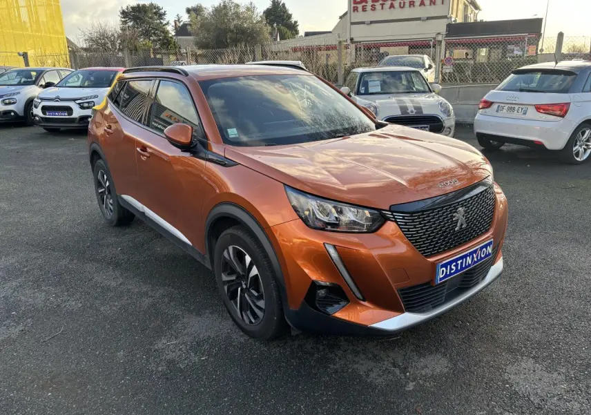 Peugeot 2008 orange fusion vue 3/4 avant droit, avec calandre noire et jantes alliage bicolores.