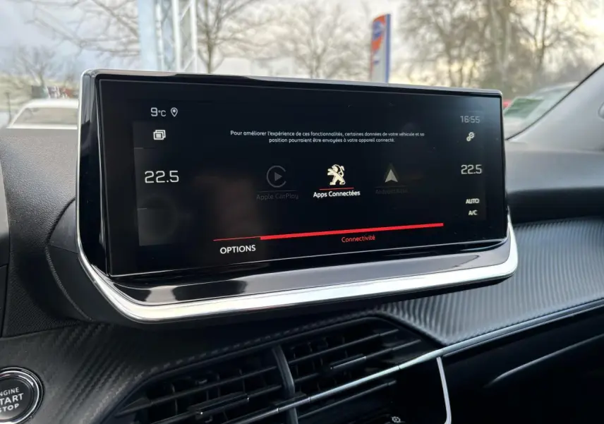Écran tactile central du Peugeot 2008 2021 affichant la connectivité Apple CarPlay, entouré d'un tableau de bord noir texturé.