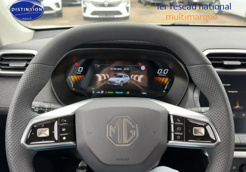 Vue intérieure centrée sur le volant MG d'un MG ZS Hybrid blanc, avec tableau de bord numérique et écran tactile visible.