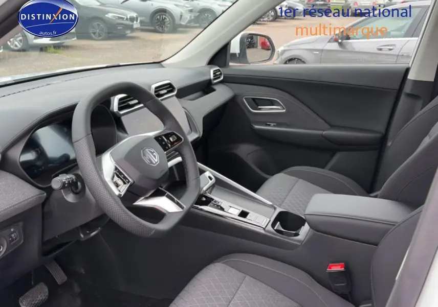 Vue intérieure côté conducteur du MG ZS Hybrid 197 blanc, avec volant multifonction et console centrale moderne.