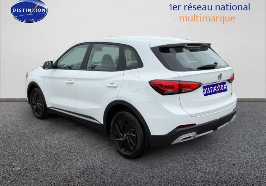 Vue 3/4 arrière droite d’un MG ZS Hybrid blanc avec jantes noires et feux arrière LED distinctifs.