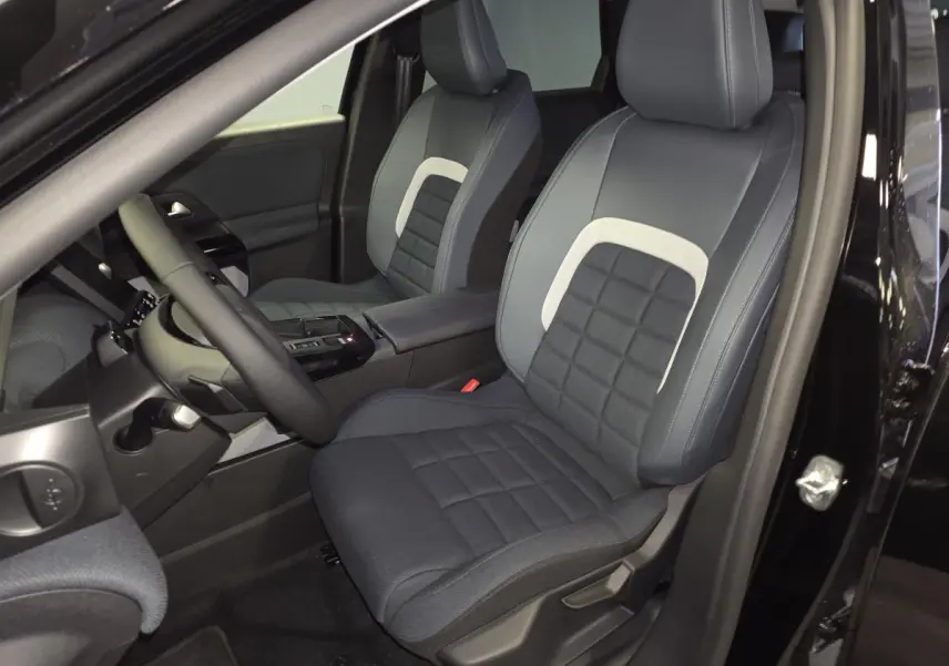Vue intérieure côté conducteur du Citroën C5 Aircross noir 2026, sièges avant en tissu bicolore avec console centrale noire.