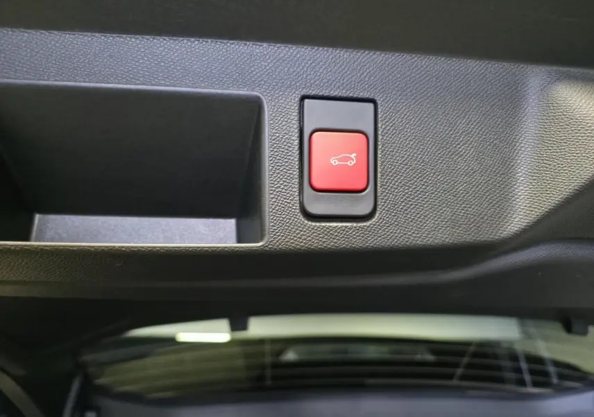 Bouton rouge d'ouverture électrique du hayon sur le panneau intérieur du coffre du Citroën C5 Aircross noir.