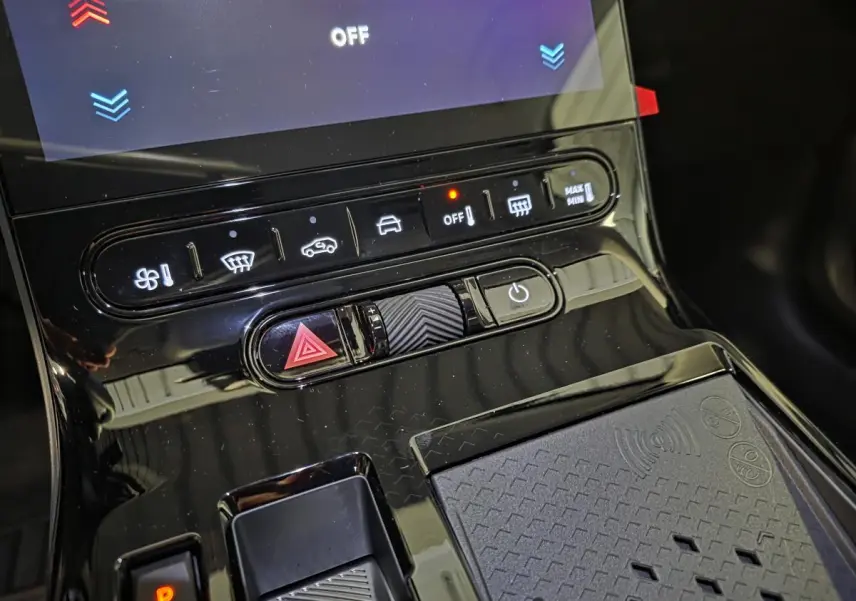 Gros plan sur la console centrale noire brillante du Citroën C5 Aircross 2026 avec commandes climatisation et recharge sans fil.