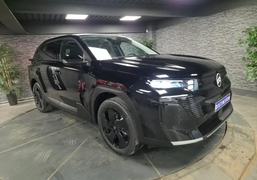 Citroën C5 Aircross noir en 3/4 avant droit, avec jantes noires et calandre brillante dans un showroom.