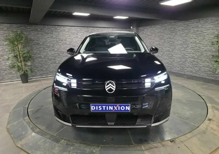 Vue avant d'un Citroën C5 Aircross noir brillant avec calandre noire et phares LED allumés en intérieur.