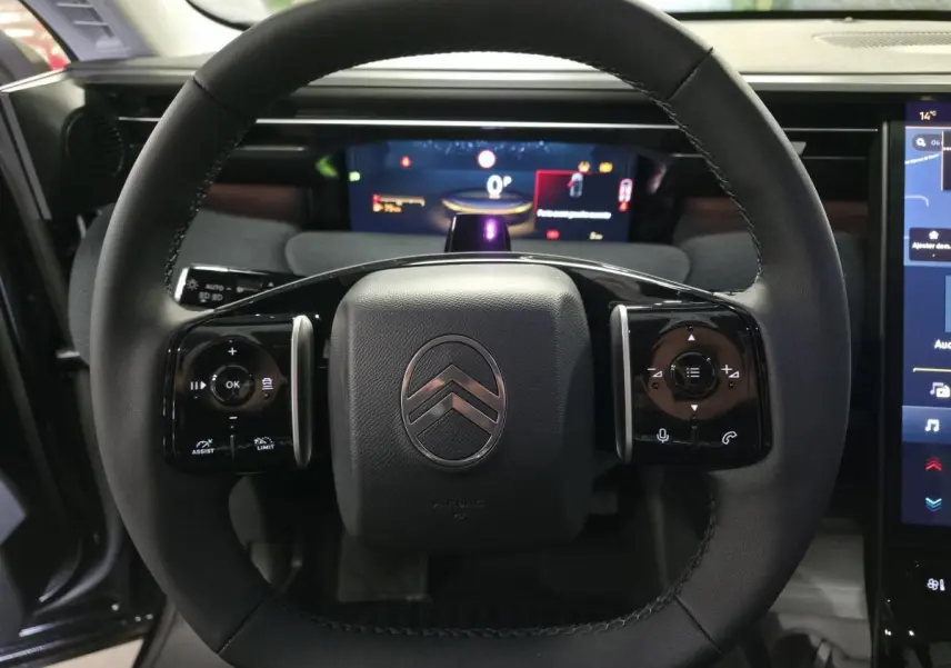 Vue rapprochée du volant noir multifonctions du Citroën C5 Aircross 2026 avec tableau de bord numérique en arrière-plan.
