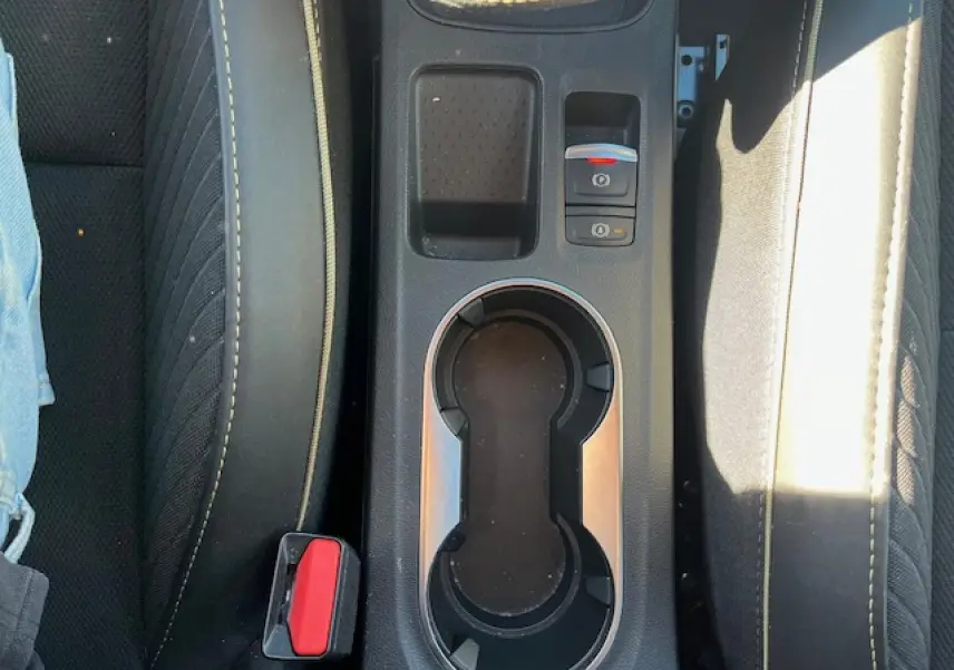 Vue plongeante sur la console centrale noire avec porte-gobelets et frein de parking électrique du Renault Symbioz 2025.