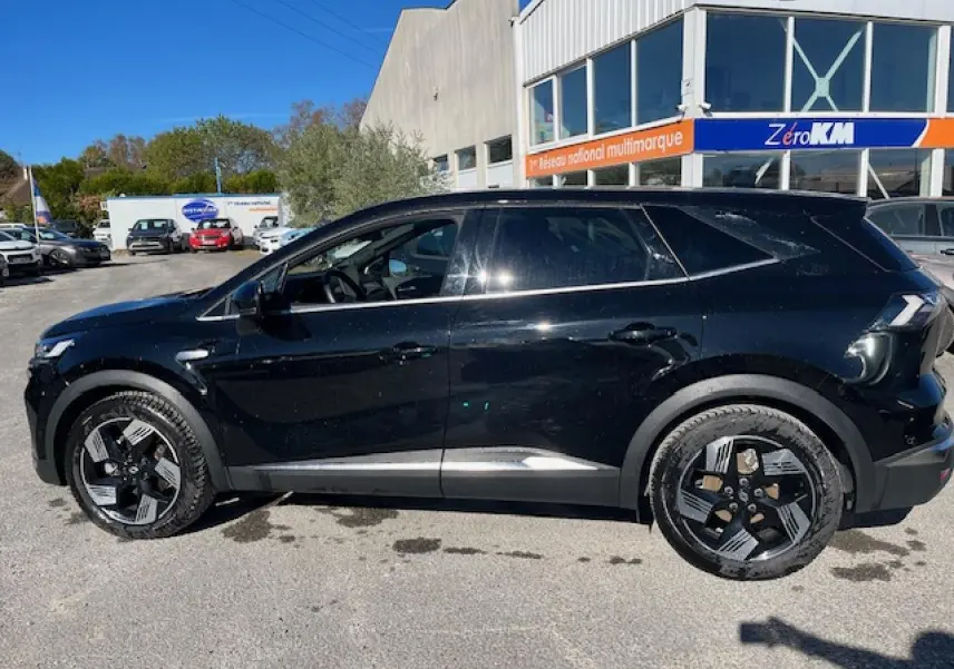 Renault Symbioz 2025 noir étoilé vu de profil côté gauche, avec jantes alliage 19 pouces et vitres surteintées.