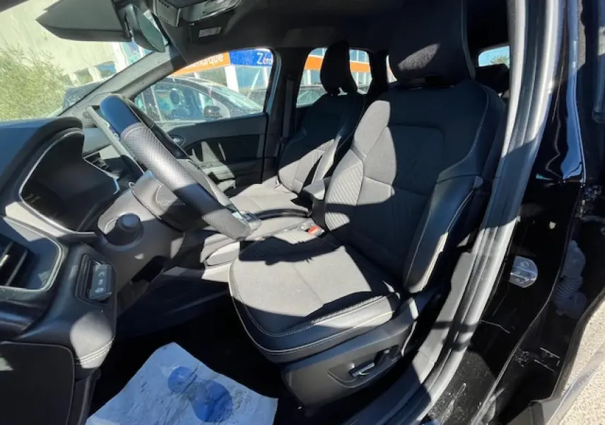 Vue intérieure côté conducteur du Renault SYMBIOZ noir, montrant les sièges avant et le volant avec commandes intégrées.