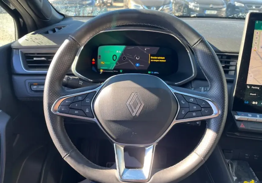 Vue rapprochée du volant noir de la Renault SYMBIOZ 2025 avec tableau de bord numérique et écran tactile latéral.
