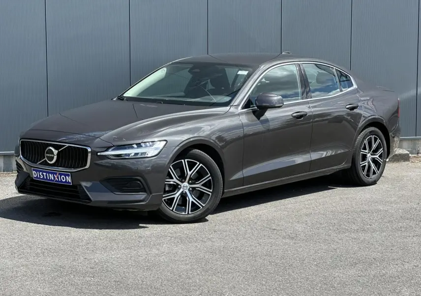 Volvo S60 B4 2024 gris Platinium vue 3/4 avant avec jantes alliage 17 pouces et calandre chromée.