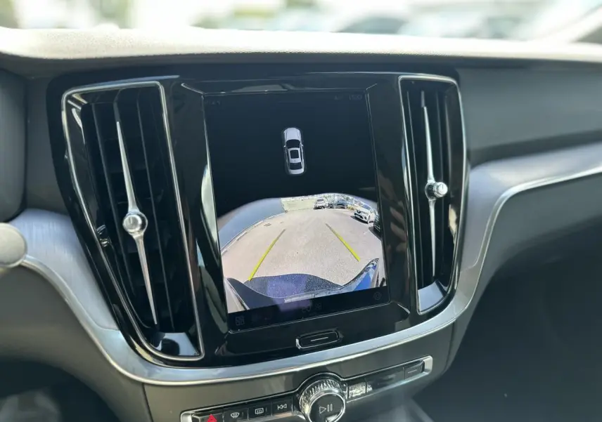 Écran tactile central affichant la caméra de recul d'une Volvo S60 gris Platinium, vue intérieure avant.