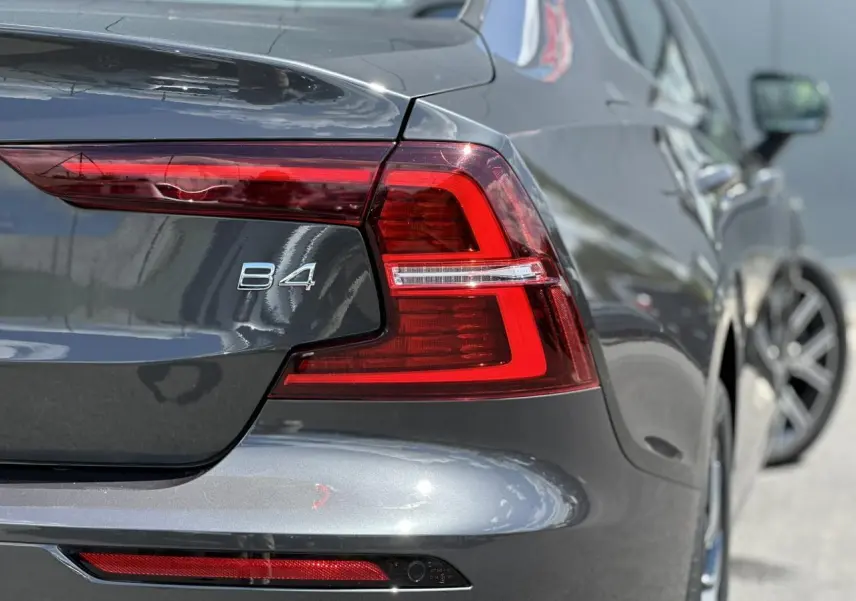 Gros plan sur l'arrière droit d'une Volvo S60 B4 gris Platinium avec feux LED et logo B4 visible.