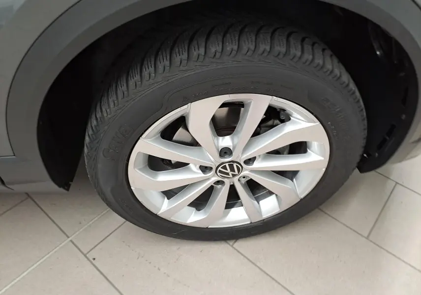 Gros plan sur la jante alliage 17'' Johannesburg et pneu du Volkswagen T-Roc gris Indium, côté avant droit.
