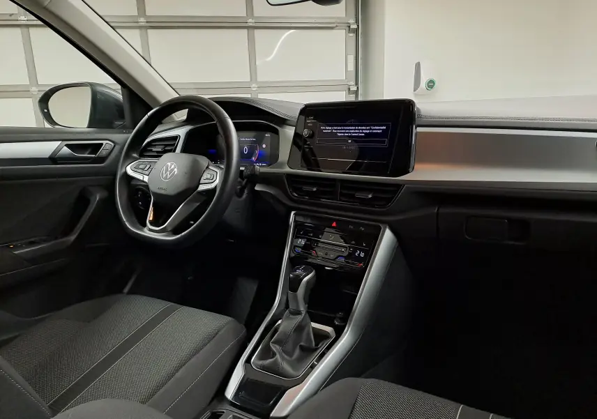 Vue intérieure côté conducteur du Volkswagen T-Roc 1.5 TSI 2024, avec tableau de bord numérique et écran tactile central.