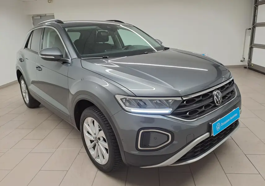 Volkswagen T-Roc 1.5 TSI gris Indium vu en 3/4 avant droit avec jantes alliage 17'' Johannesburg et feux LED allumés.