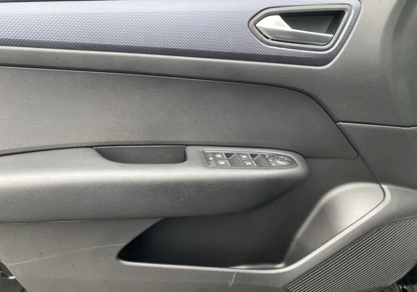 Détail de la porte côté gauche intérieure du Renault Arkana noir 2024 avec commandes de vitres et haut-parleur intégré.