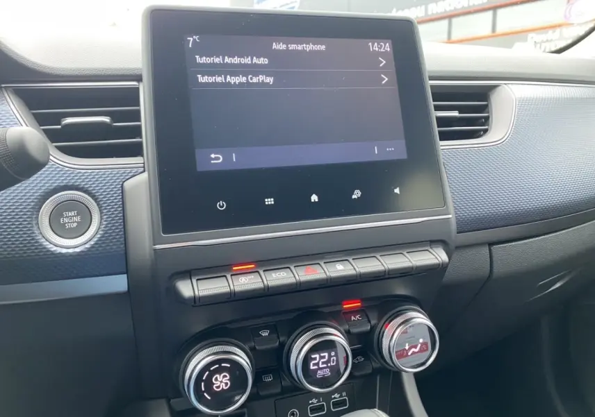 Vue rapprochée de la console centrale du Renault Arkana 2024 noire, écran tactile et commandes climatisation visibles.