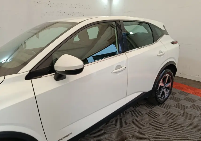 Vue côté gauche du Nissan Qashqai e-Power blanc, mettant en valeur la porte arrière, le rétroviseur et la jante alliage.