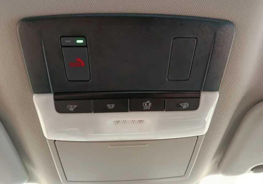 Vue en gros plan du panneau de commandes au plafond intérieur du Nissan Qashqai e-Power blanc, avec bouton SOS et éclairage.