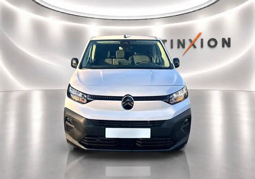 Vue frontale d'un Citroën Berlingo Fourgon blanc 2026 avec pare-chocs noir et phares LED dans un studio lumineux.