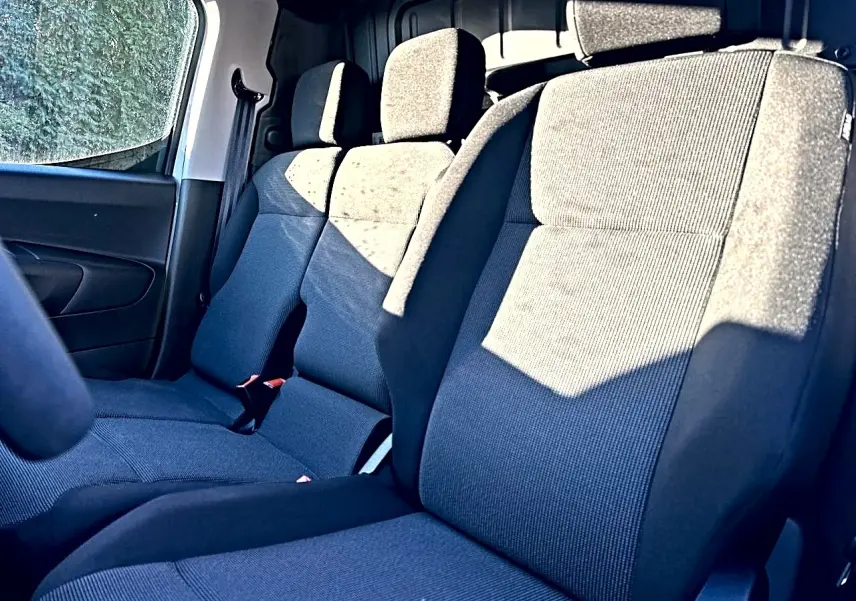 Vue intérieure rapprochée des sièges avant en tissu gris foncé du Citroën Berlingo Fourgon M diesel 100 2026.
