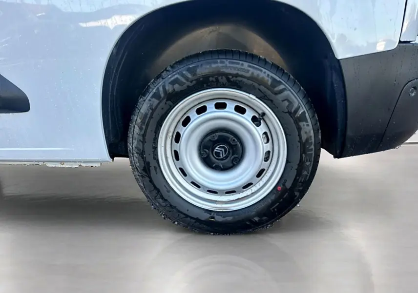 Gros plan sur la roue arrière droite blanche d’un Citroën Berlingo Fourgon M diesel 100, avec jante acier.