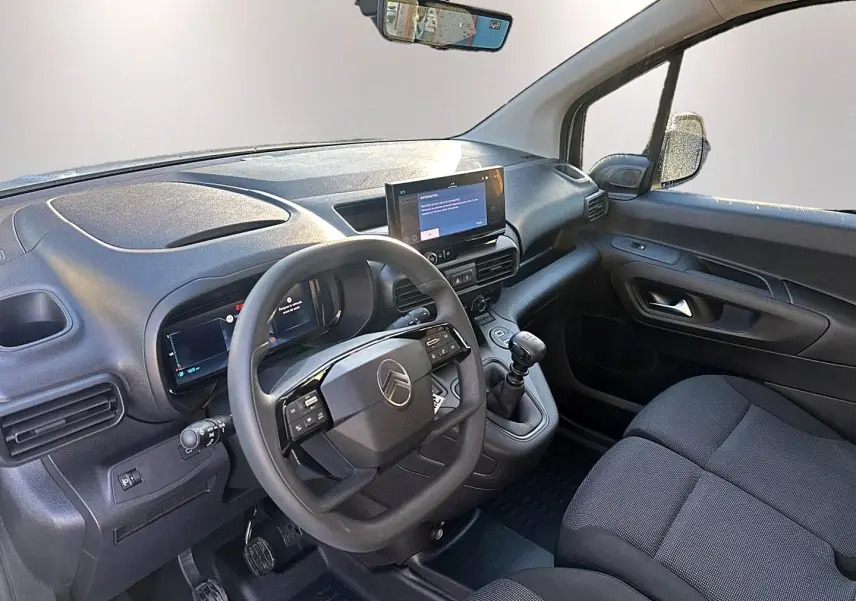 Vue intérieure côté conducteur du Citroën Berlingo Fourgon blanc, montrant le volant multifonction et la tablette tactile centrale.