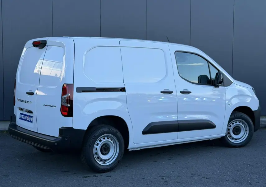 Vue 3/4 arrière droite du Peugeot Partner blanc Icy avec portes arrière battantes et protections latérales noires.