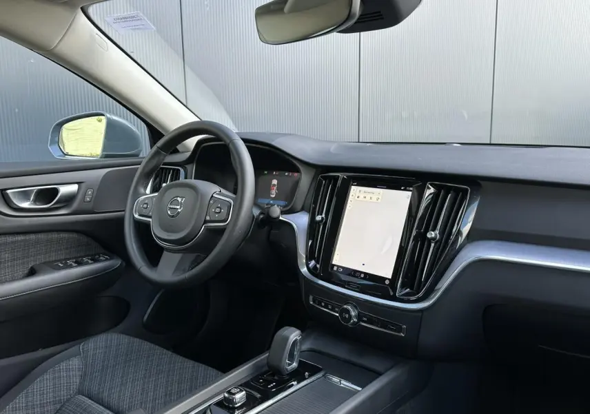 Intérieur avant droit de la Volvo S60 gris Thunder 2024, volant multifonction et écran tactile central visible